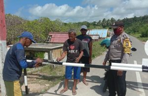 Cegah Covid 19, Bhabinkamtibmas Lorulun Bersama Warga Memasang Palang Pada Pintu Masuk Desa