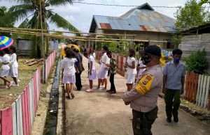 Bhabinkamtibmas Bomaki Giat Pengamanan Tradisi Nalole Anak Yesus Umat Stasi St. Paulus